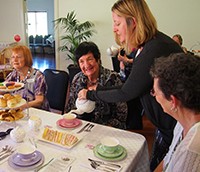 Identitywa staff member serving tea to carers