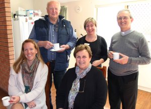 Father Nino enjoying a cup of tea with staff and an Identitywa family.