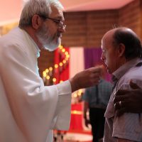 Man receiving Communion at Identitywa Easter season Mass